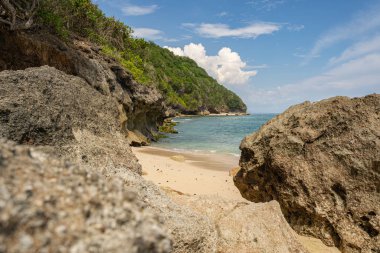 Kayaların arasında güzel, vahşi bir sahil.