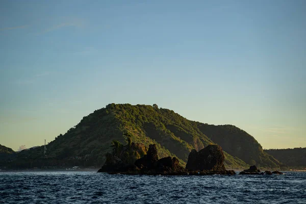 Grande roccia sulla riva dell'oceano ondulato — Foto Stock
