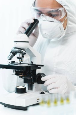 Concentrated young medical worker using modern microscope