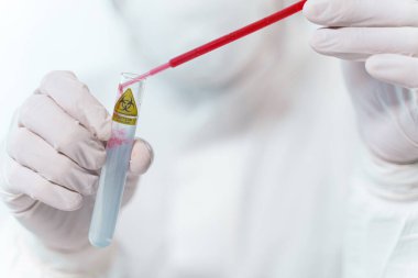 Professional medical worker using pipette during research