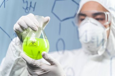 Attentive young researcher doing checkup of reagent