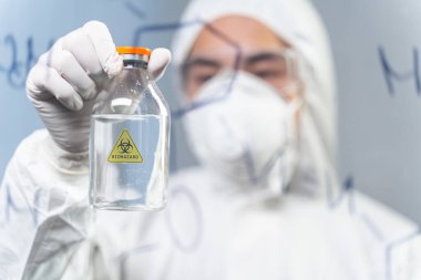 Close up of attentive man that staring at glass bottle