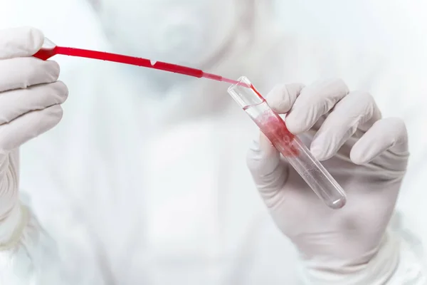 Close up of pipette that pouring down red liquid — 图库照片