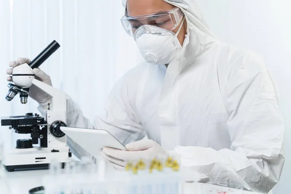 Attentive Asian researcher looking at screen of his gadget