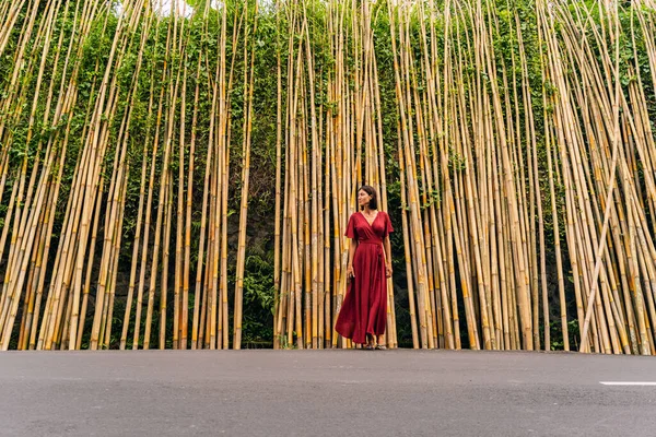 Charming girl standing on the bamboo background — Stock fotografie