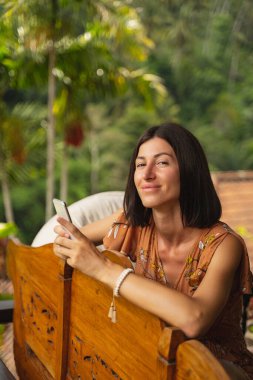 Güzel esmer kız doğrudan kameraya bakıyor.