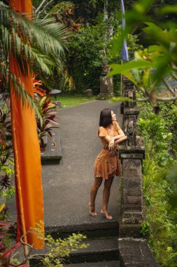 Rahat esmer kız yürürken taşlara yaslanıyor.