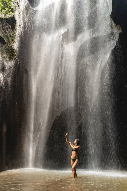 Beautiful slim model standing near the waterfall