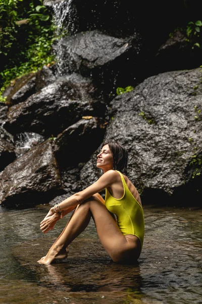 Positiva chica morena encantada sentada en el agua — Foto de Stock