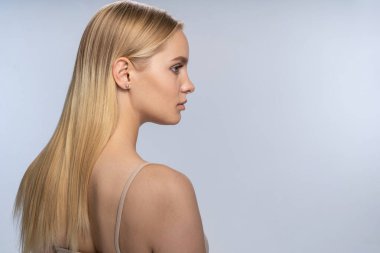 Good-looking focused Caucasian girl standing alone indoors