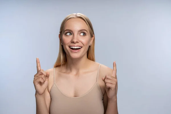 Jovem fêmea com um sorriso de dente olhando para o lado — Fotografia de Stock