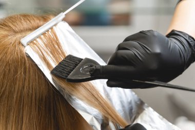 Professional hairdresser using sterile instruments while dying