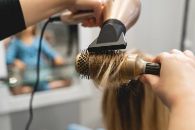 Young blonde woman sitting in beauty salon