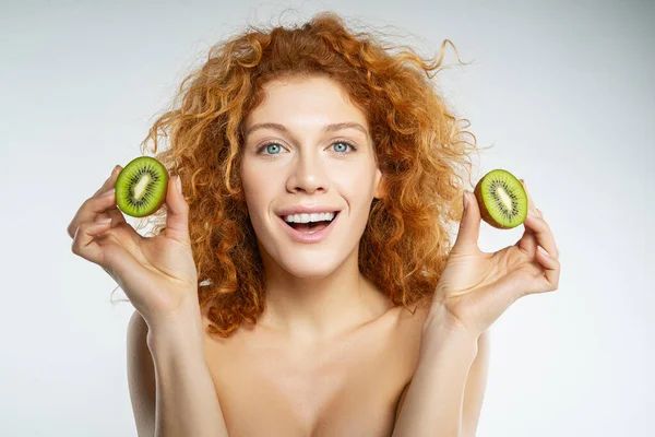 Primer plano de chica bonita que la celebración de kiwi — Foto de Stock