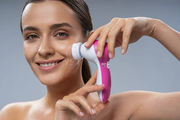 Happy pretty lady cleaning face skin with brush — Φωτογραφία Αρχείου