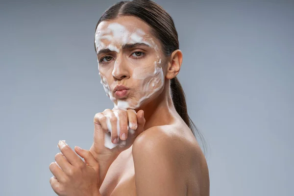 Hermosa mujer lavándose la cara con las manos con jabón — Foto de Stock