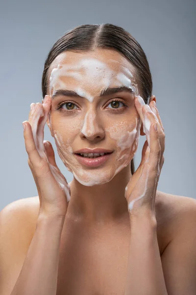 Happy pretty woman washing her face with soap — Stock Photo, Image