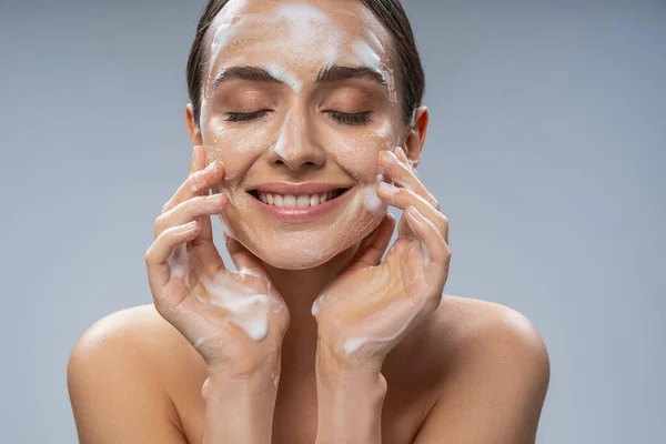 Wanita cantik muda mencuci wajahnya dengan sabun — Stok Foto