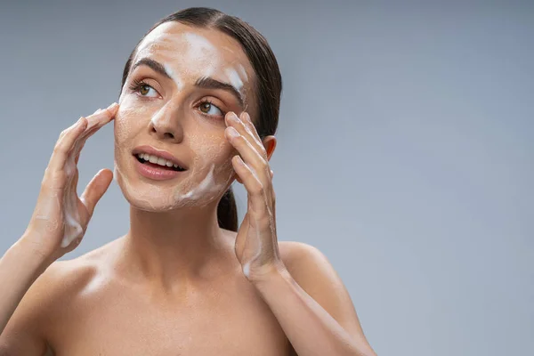 Feliz hembra lavándose la cara con las manos con jabón —  Fotos de Stock