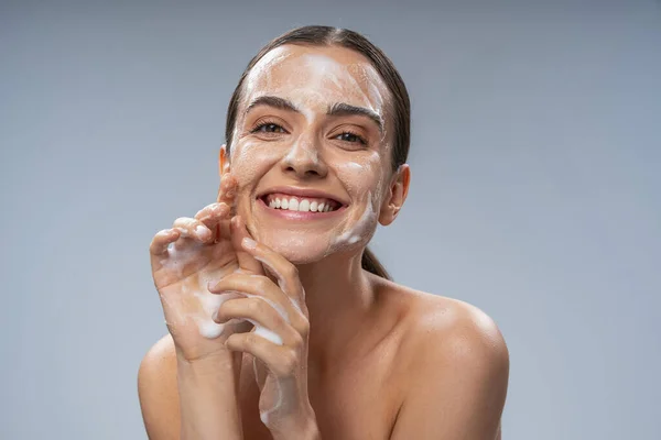 Happy Caucasian wanita mencuci muka dengan sabun putih — Stok Foto