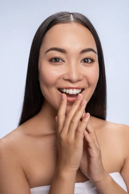 Beautiful lady touching face with hand in studio