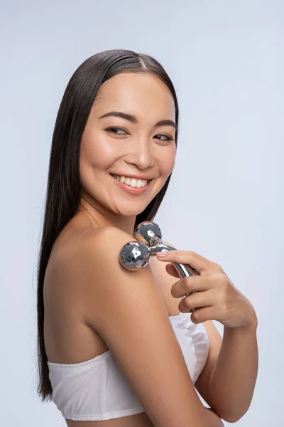 Mujer bonita sonriente está cuidando su piel en el estudio —  Fotos de Stock