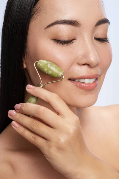 Happy lady is using natural face roller — 스톡 사진