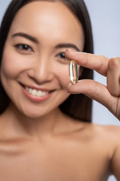 Donna felice tenendo pillola con olio di pesce omega-3 — Foto Stock