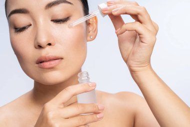 Gözleri kapalı güzel bir kadın. Yüzünde serum var.