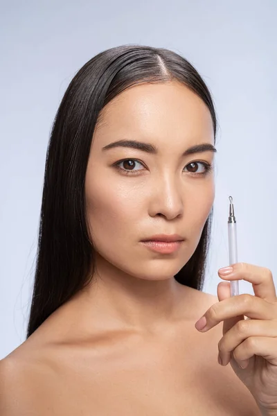 Bella asiatico donna è holding comedone estrattore — Foto Stock