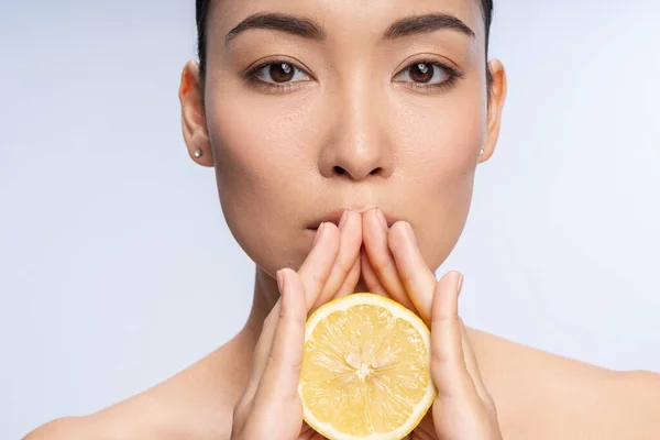 Bastante asiático mujer con medio limón posando en cámara — Foto de Stock