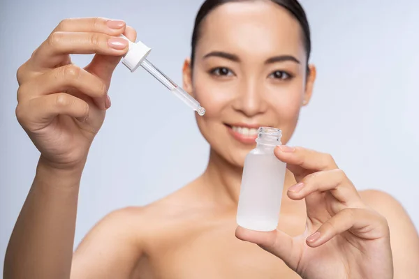 Smiling Asian lady getting special skin treatment — Stock Photo, Image