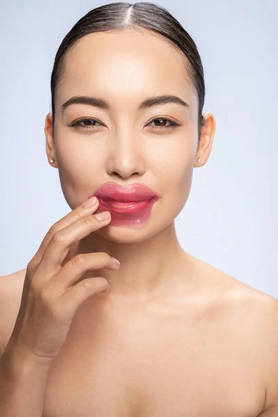 Glimlachende vrouw houdt vlekken op lippen — Stockfoto
