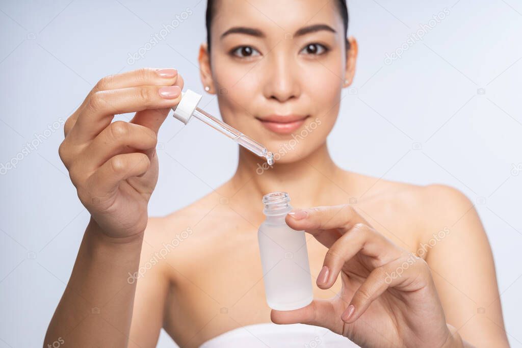 Happy Asian woman getting special skin treatment