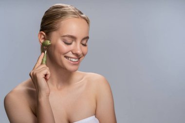 Tatlı sarışın kadın yüz masajı yapıyor.