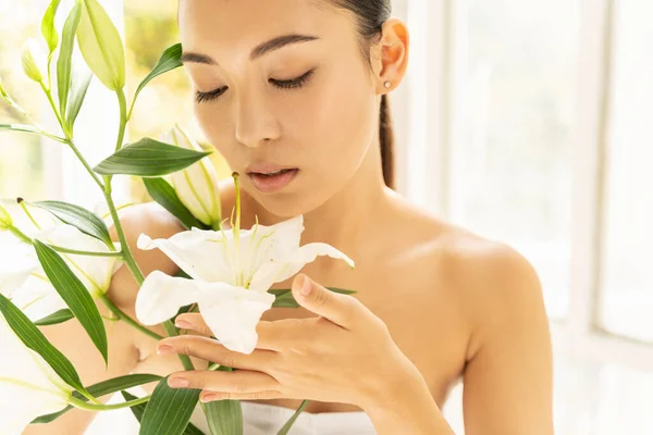 Hermosa señora asiática con flores en la habitación — Foto de Stock