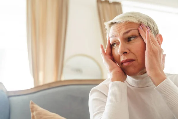 頭痛で苦しんでいる悲しい高齢者の女性 — ストック写真