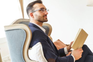 Kanepede dinlenen zarif bir genç adam.