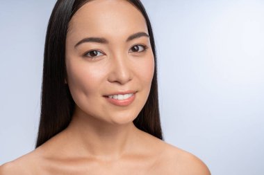 Genç esmer kadın, beyazın üzerinde tek başına duruyor.