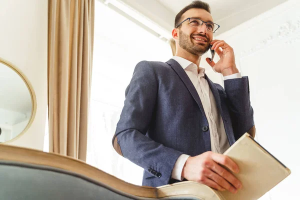 Man met een smartphone die zijn notitieblok vasthoudt — Stockfoto