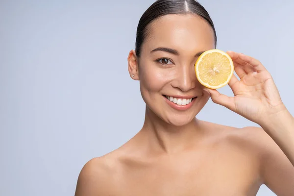 Pozitivní nadšené samice pózující na kameře s citronem — Stock fotografie