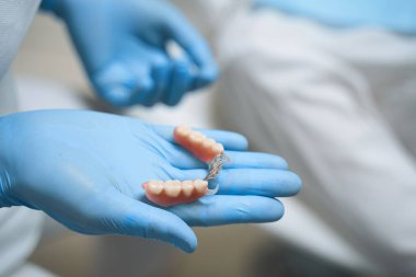 Diş hekimi stok fotoğrafında implantlar tutuyor.