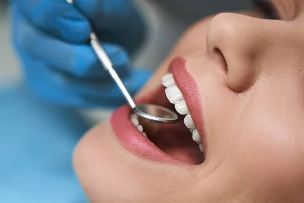 Dentista está examinando joven mujer stock foto — Foto de Stock