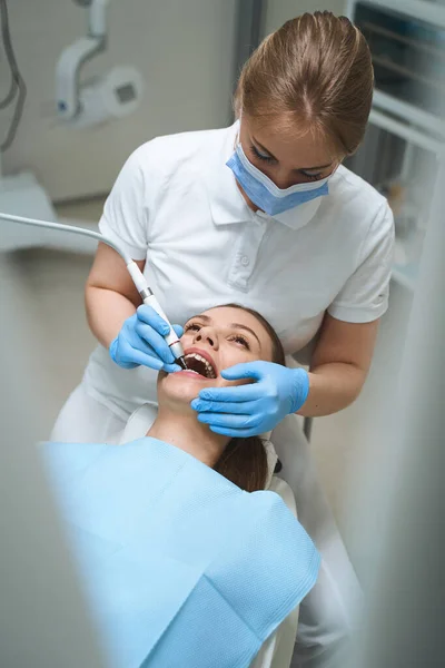 Mujer dentista tratamiento paciente en clínica stock foto — Foto de Stock