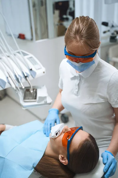 Mujer dentista teniendo cuidado de paciente stock foto — Foto de Stock