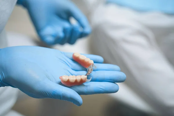 Tandläkare som håller implantat i handen stock foto — Stockfoto