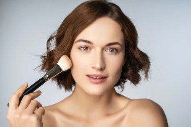 Çekici esmer kadın kişi dekoratif kozmetik testleri yapıyor.