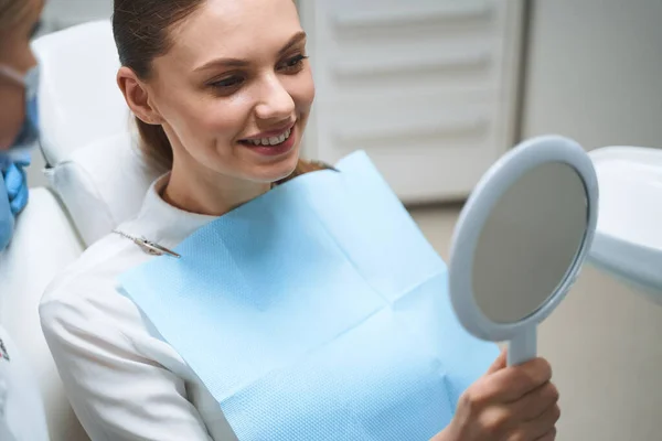 Mujer encantada después de los procedimientos con foto de stock dentista — Foto de Stock