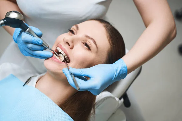 Ung kvinna som behandlar tänder på klinik stock foto — Stockfoto