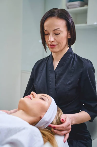 Professional beautician working her client in salon — Stock Photo, Image